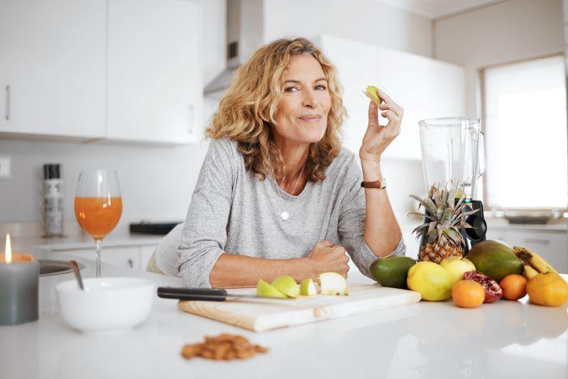 Healthy mature woman snacking on an apple