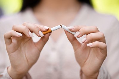 Woman breaking a cigarette in half