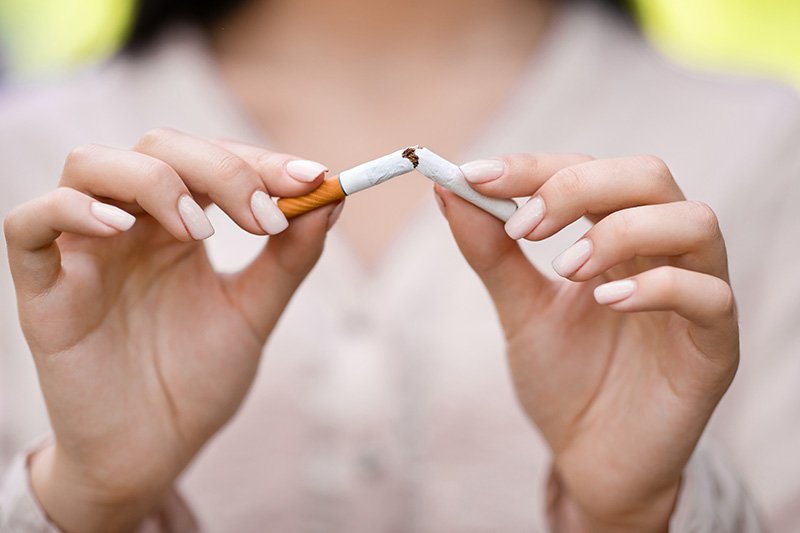 Woman breaking a cigarette in half