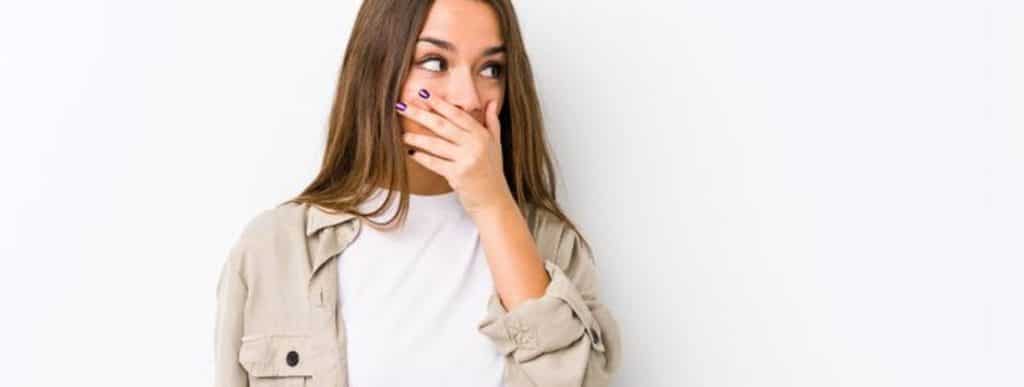 Young woman covering her mouth with her hand